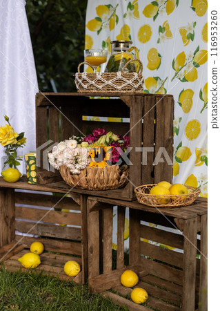 Basket of lemons. Decorations with lemons. Photo zone with citrus fruits Basket of lemons. Decorations with lemons. Photo zone with citrus fruits 116953260