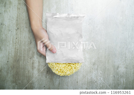 A hand holding a bag of instant noodles with a white plastic bag over it 116953261