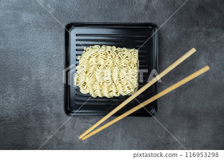 A plate of instant noodles with chopsticks on top A plate of instant noodles with chopsticks on top 116953298