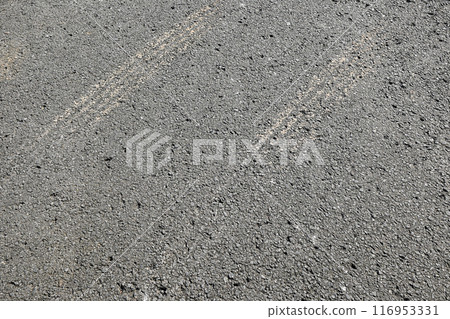 A grey and black pavement with a white line 116953331