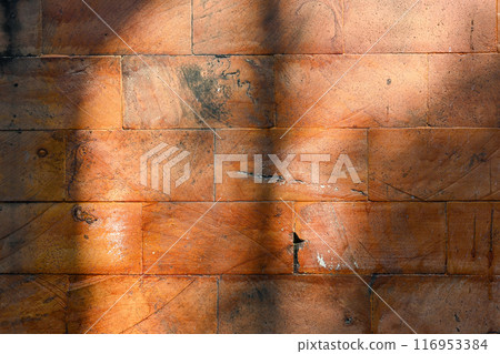 A brick wall with a shadow cast on it A brick wall with a shadow cast on it 116953384
