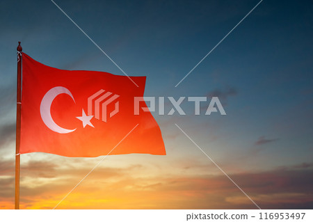 A Turkey flag with a star and crescent moon flying in the sky 116953497