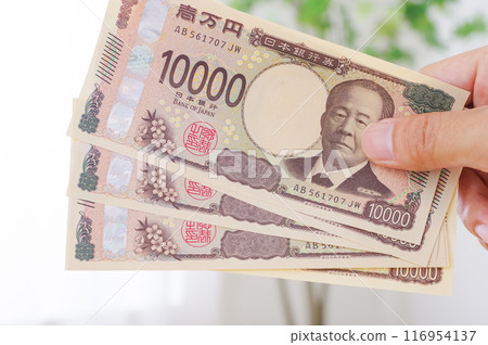 A man holding 100,000 yen in his hand 116954137