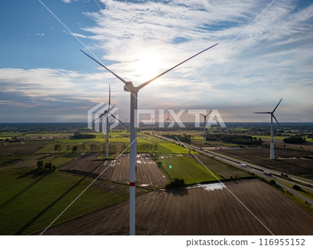 At sunset, wind turbines in the countryside display harmony between nature and innovation 116955152