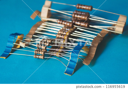 Several through hole resistors on top of a blue table Several through hole resistors on top of a blue table 116955619