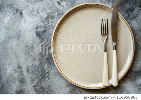 Empty plate, knife and fork on concrete background. Top view. 116956963