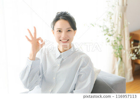 A woman in her 30s making an OK pose with her fingers 116957113