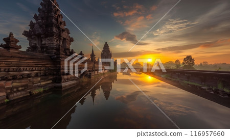 A serene sunrise graces an ancient temple, illuminating its carvings with the first light of dawn. 116957660