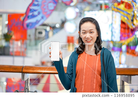 clear empty solid white mobile screen in Asian woman hand in department store background. For website or application interface mock up on smart phone. Clipping Path. clear empty solid white mobile screen in Asian woman hand in department store background. For website or application interface mock up on smart phone. Clipping Path. 116958895