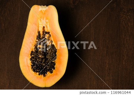 Half of a juicy ripe papaya on a brown background Half of a juicy ripe papaya on a brown background 116961044