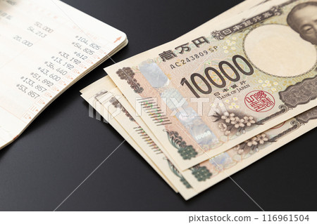 黑色背景上的存摺和 10,000 日元鈔票 116961504