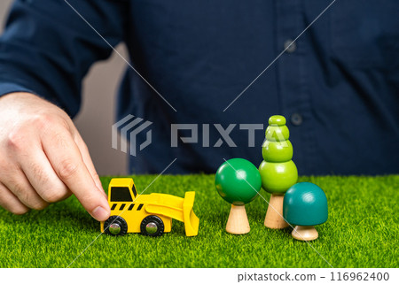 A man with a bulldozer is going to cut down trees in a forest. Clearing land for construction. Illegal logging. Protect the environment, stop deforestation. A man with a bulldozer is going to cut down trees in a forest. Clearing land for construction. Illegal logging. Protect the environment, stop deforestation. 116962400