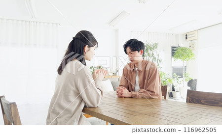 Couple having a serious conversation in the living room Couple having a serious conversation in the living room 116962505