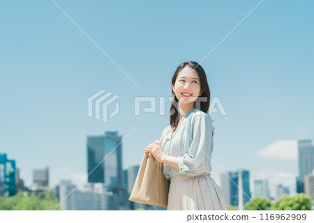 Business woman against the backdrop of the blue sky and buildings 116962909