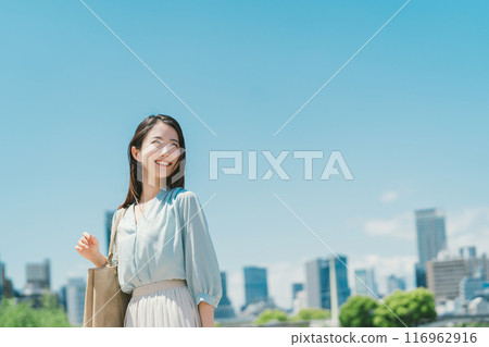 Business woman against the backdrop of the blue sky and buildings 116962916
