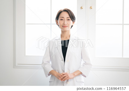 Woman in white coat looking at camera Woman in white coat looking at camera 116964557