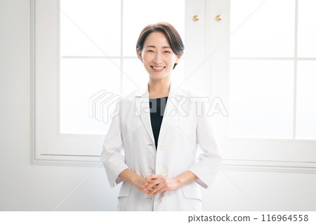 Woman in white coat looking at camera 116964558