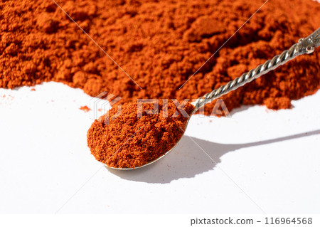 Ground smoked paprika in a spoon on a white background. Ground smoked paprika in a spoon on a white background. 116964568