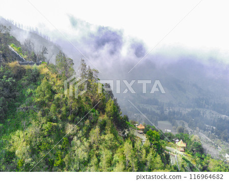 Aerial view of a misty mountain landscape with lush green vegetation near Bromo 116964682