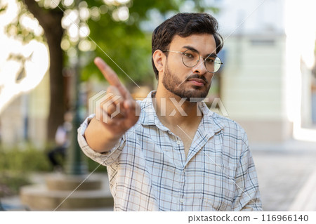 Upset Indian man reacting to unpleasant idea, dissatisfied with bad quality, wave finger on street 116966140
