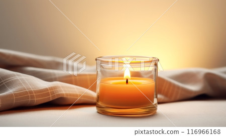 A lit candle sitting on top of a blanket 116966168