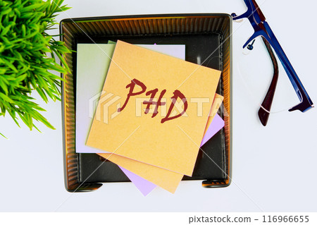 Doctorate of Philosophy concept. PhD on yellow sticker has a top view 116966655