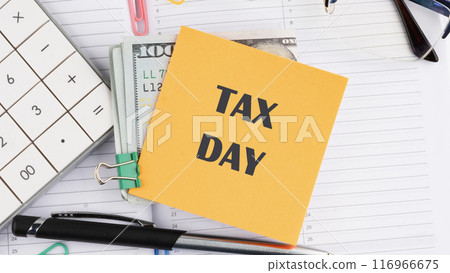 Tax Day Taxation Financial Money Money Concept. Words TAX DAY on a yellow sticker on American banknotes on the background of a business notebook 116966675