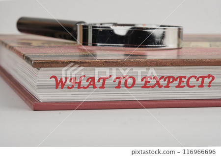 Technological Improvement. Text What To Expect on the end of the book with a magnifying glass on top on a white background Technological Improvement. Text What To Expect on the end of the book with a magnifying glass on top on a white background 116966696