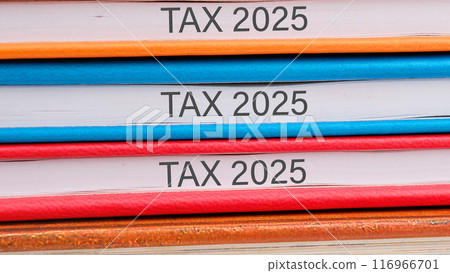 Conceptual tax 2025 symbol. Copy space. Tax 2025 words written close-up on the ends of the notebooks Conceptual tax 2025 symbol. Copy space. Tax 2025 words written close-up on the ends of the notebooks 116966701