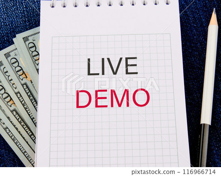 Copy space. Business and live demo concept. Live demo symbol in a notebook in a composition with American hundred dollar bills and a pencil 116966714
