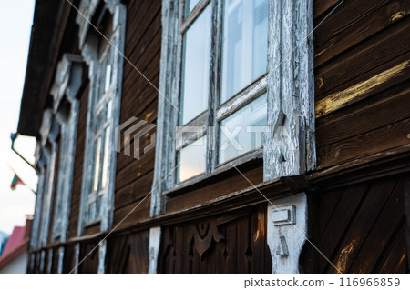 An old, vintage, wooden building. White, wooden windows in it 116966859