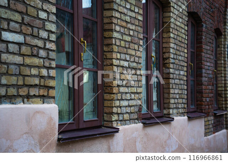 An old, vintage, brick building. Maroon, wooden windows in it An old, vintage, brick building. Maroon, wooden windows in it 116966861