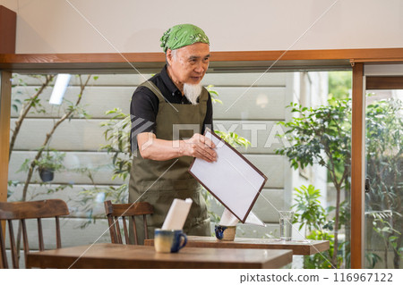 A man in his 60s is pursuing a fulfilling second career as a cafe owner after retirement 116967122