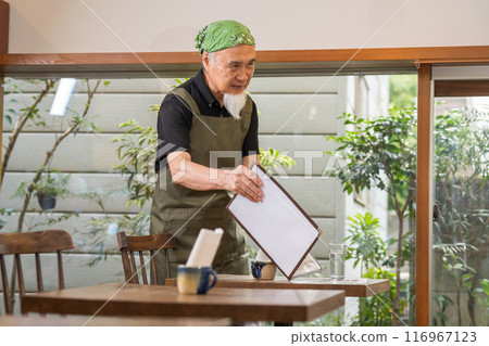 A man in his 60s is pursuing a fulfilling second career as a cafe owner after retirement 116967123