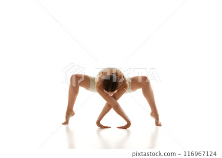 Athletic, flexible young woman dressed active wear demonstrates deep stretch in her yoga practice against white studio background. 116967124