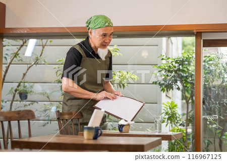 A man in his 60s is pursuing a fulfilling second career as a cafe owner after retirement 116967125