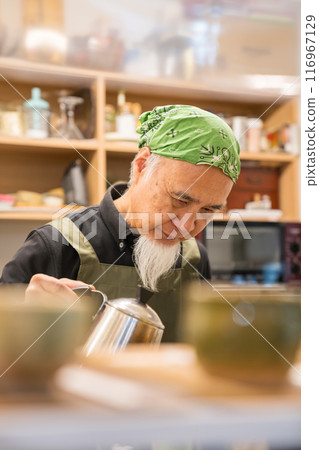A man in his 60s is pursuing a fulfilling second career as a cafe owner after retirement 116967129