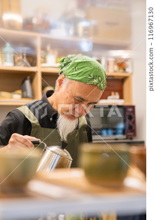 A man in his 60s is pursuing a fulfilling second career as a cafe owner after retirement 116967130