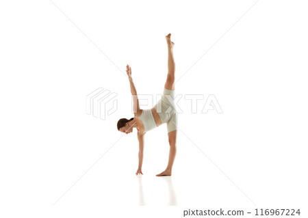 Half Moon pose. Athletic young woman practices against white studio background, training strength and body awareness. 116967224