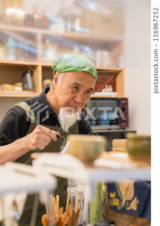 A man in his 60s is pursuing a fulfilling second career as a cafe owner after retirement 116967252