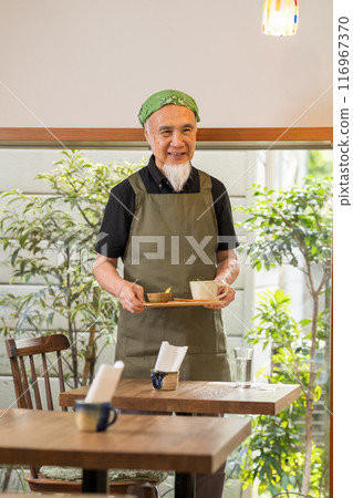 一名 60 多歲的男子退休後正在豐富自己的第二份職業，成為咖啡館老闆。 116967370