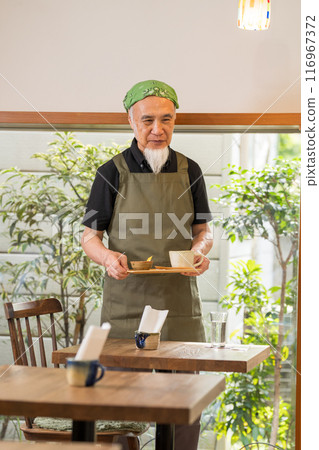 一名 60 多歲的男子退休後正在豐富自己的第二份職業，成為咖啡館老闆。 116967372