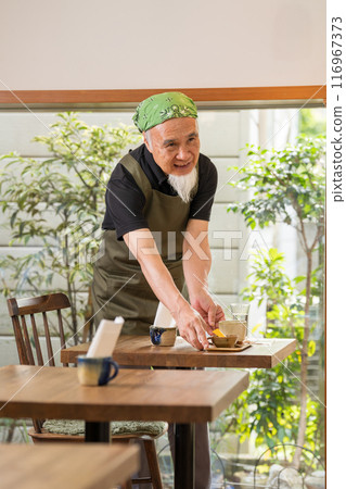 一名 60 多歲的男子退休後正在豐富自己的第二份職業，成為咖啡館老闆。 116967373