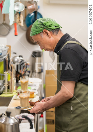 一名 60 多歲的男子退休後正在豐富自己的第二份職業，成為咖啡館老闆。 116967401