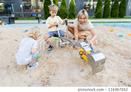 Mother Enjoys Quality Time With Two Sons Playing in the Sand at Local Playground Mother Enjoys Quality Time With Two Sons Playing in the Sand at Local Playground 116967882