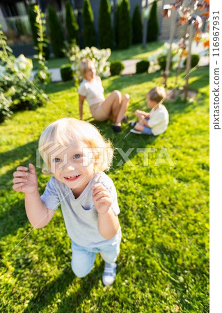 Joyful Mother Engaging With Her Two Sons at a Playground During a Sunny Day Joyful Mother Engaging With Her Two Sons at a Playground During a Sunny Day 116967931