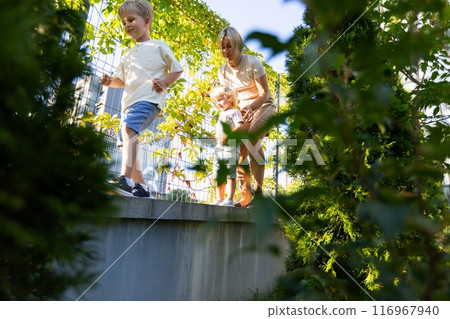 Mother Enjoying Quality Time With Her Two Sons at the Playground During a Sunny Day Mother Enjoying Quality Time With Her Two Sons at the Playground During a Sunny Day 116967940