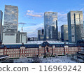 The red brick building of Tokyo Station with skyscrapers reflecting the blue sky in the background 116969242
