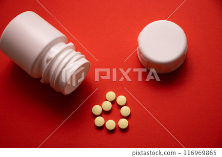 medicine bottle and pills on red background. medicine bottle and pills on red background. 116969865