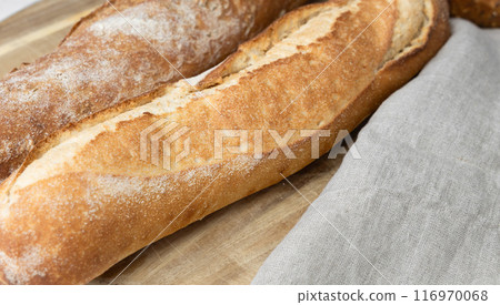 Two fresh baguettes on a cutting board. Two fresh baguettes on a cutting board. 116970068